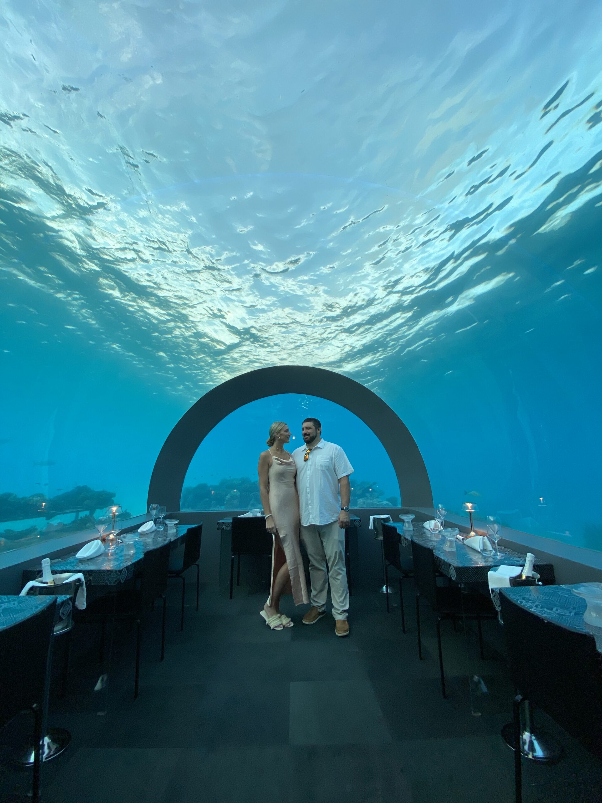 A couple on the ocean floor in an underwater restaurant in the Maldives, manifesting their intentions after performing Allie's concepts. 